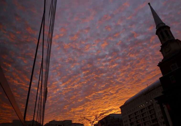 Early morning clouds are reflected in a window at sunrise across the New York Avenue Presbyterian Church steeple in Washington January 6, 2012. 
