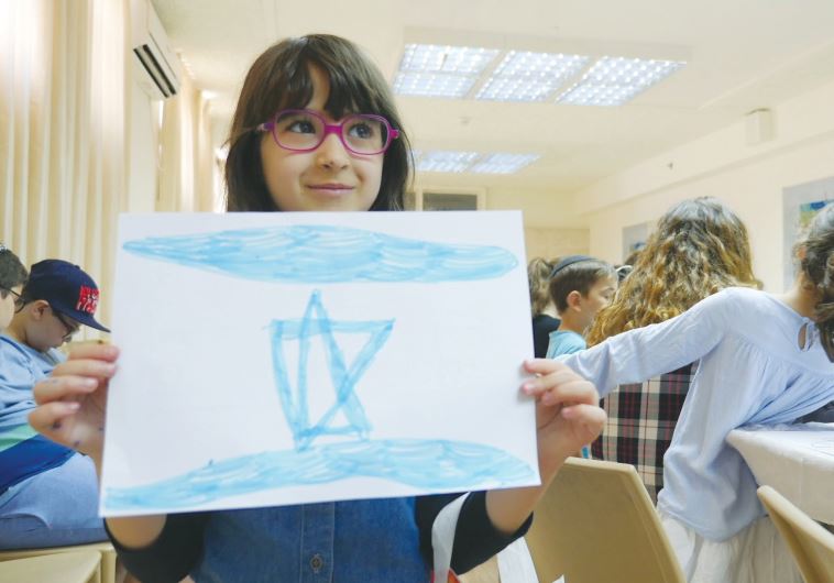 SIX-YEAR-OLD Sarit Ben-Hanni shows the colors of her new country, in an IFCJ-run activity in Jerusalem yesterday. (