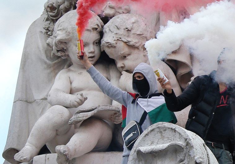 Protesters climb on the statue in the Place de la République in Paris during a banned demonstration in support of Gaza on July 26, 2014