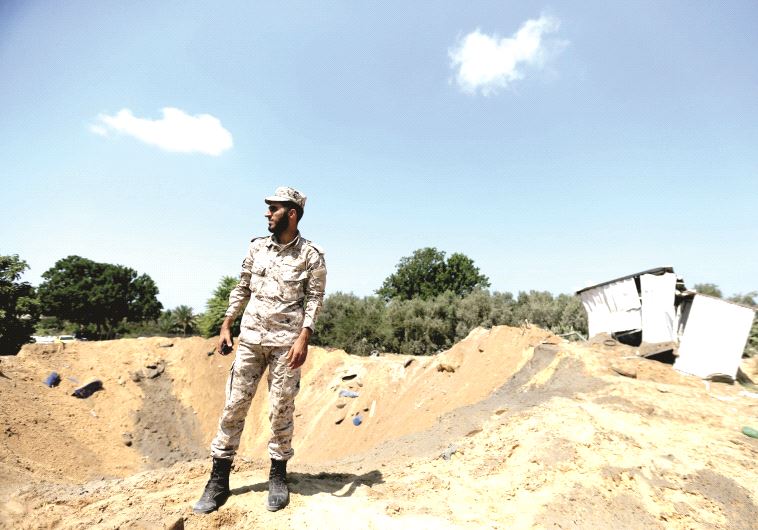 Un agent de sécurité du Hamas examine un cratère après la frappe israélienne