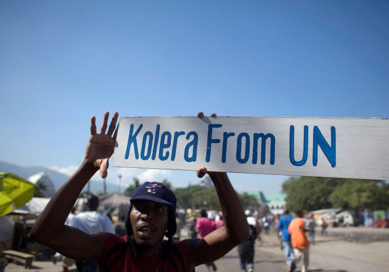  A protester holds up a sign during a demonstration against the UN mission in downtown Port-au-Prince November 18, 2010