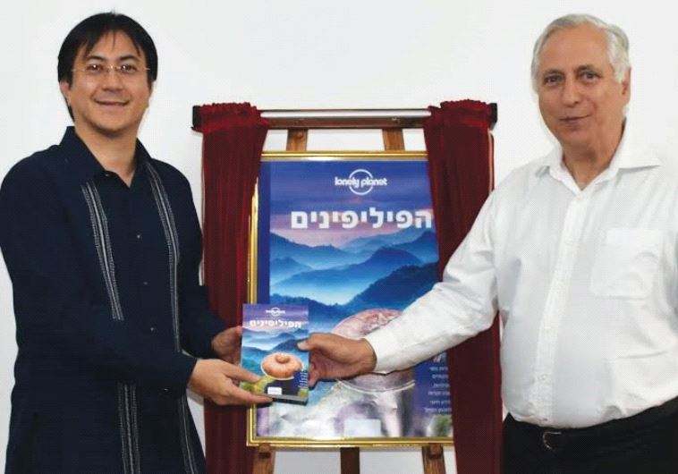 FILIPINO AMBASSADOR Neal Imperial (left) presents a Hebrew edition of the Lonely Planet Philippines guidebook to Boaz Waksman of Ophir Tours.