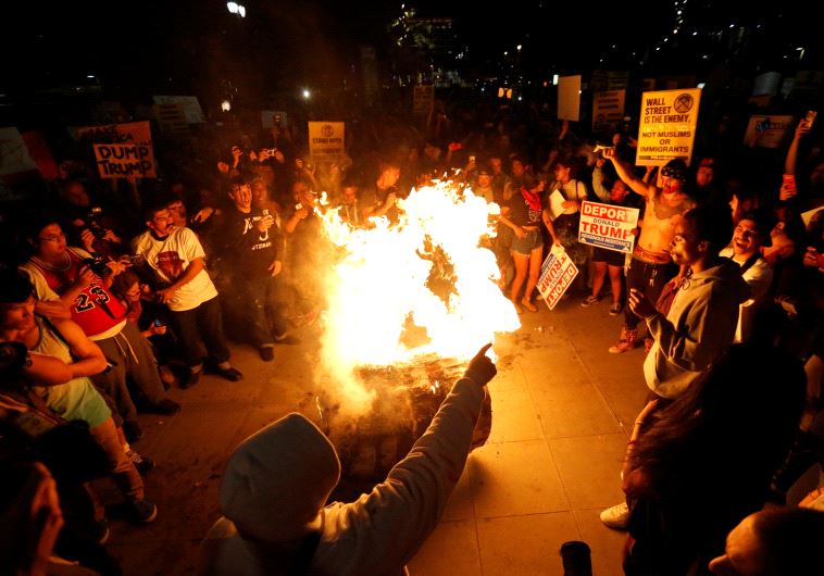 A Donald Trump pinata is burned by people protesting the election of Republican Donald Trump as the president of the United States in downtown Los Angeles, California U.S., November 9, 2016.