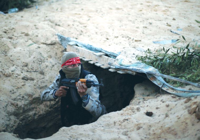 A PALESTINIAN TERRORIST climbs out of a tunnel in the Gaza Strip during a graduation ceremony in Rafah earlier this month.