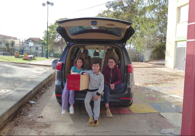 A grateful family loads their car with supplies in Zichron Ya’acov