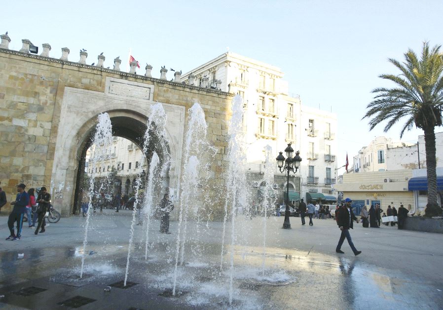 People walk past the arch of Bab el-Bhar, also known as the French gate, at the entrance of the medina district in Tunis, last year