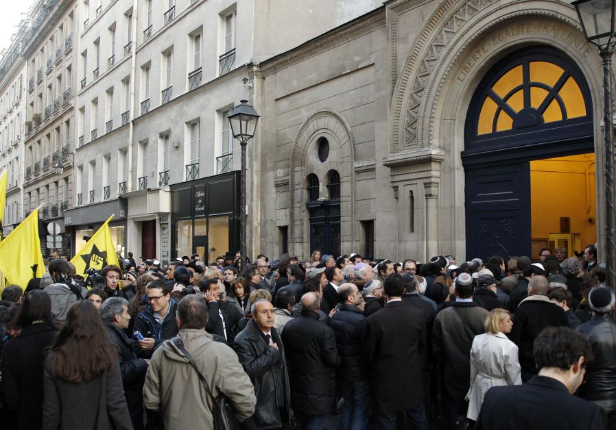 People gather outside the Notre-Dame de Nazareth synagogue in Paris March 19, 2012 to pay tribute to the four victims killed by a gunman at a Jewish school in Toulouse