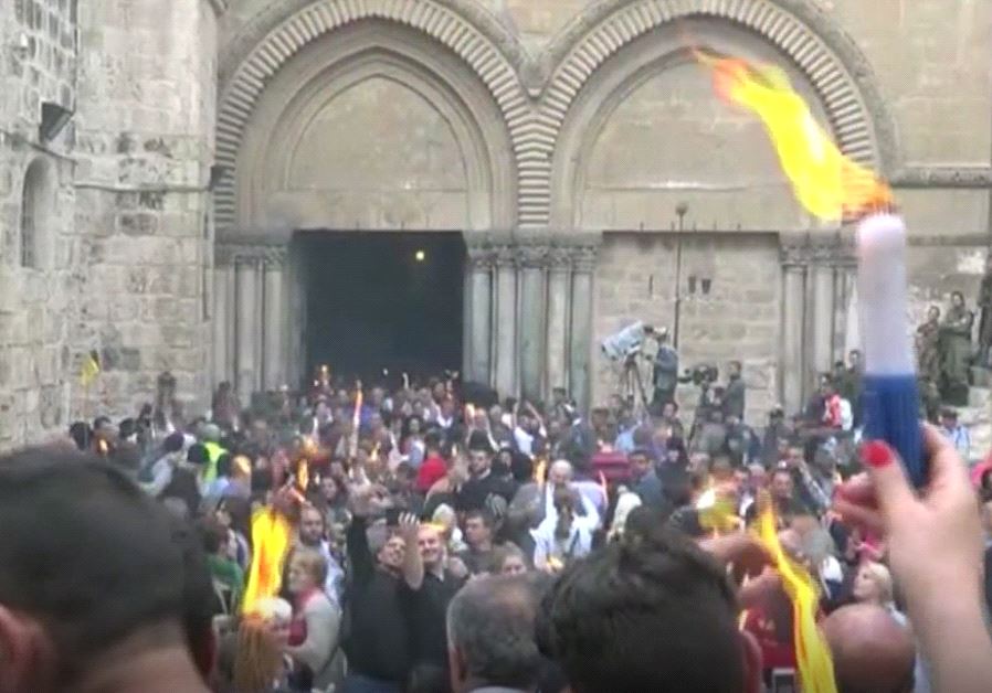 Worshipers in the Holy Sepulchre light candles with Holy Fire