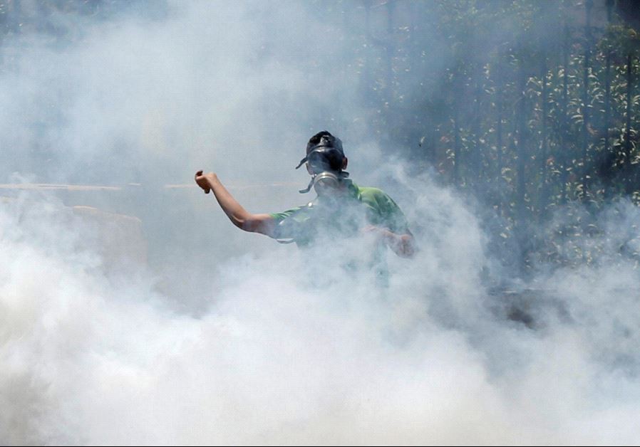 A Palestinian protester hurls stones towards Israeli troops as he reacts to tear gas during clashes following a protest in solidarity with Palestinian prisoners held by Israel, in the West Bank town of Bethlehem April 17, 2017. 