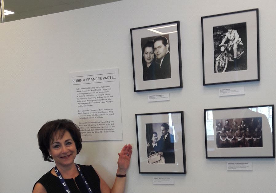 HARRIET SCHLEIFER, AJC Board of Governors Chair, proudly poses at the organization's new AJC office beside pictures of her parents who were Holocaust survivors from Poland