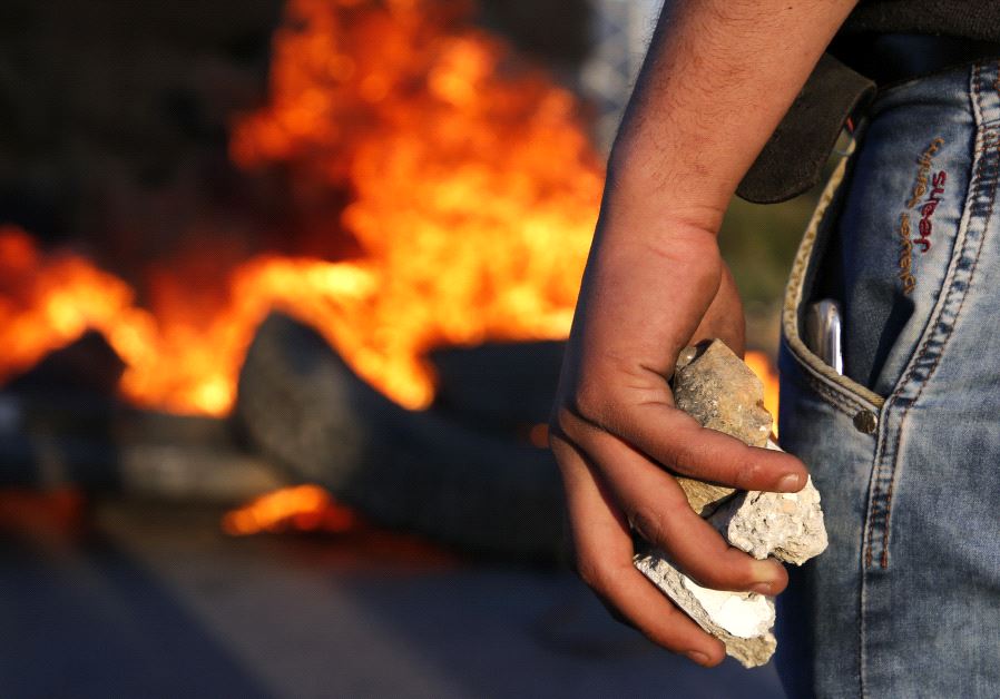 A Palestinian protestor hold stones during clashes with Israeli security forces following a protest in support of Palestinian prisoners on hunger strike in Israeli jails, near the Jewish settlement of Beit El, north of the West Bank city of Ramallah on April 24, 2017