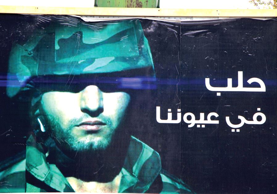 A poster placed by the Syrian authorities in western Aleppo shows a member of the security forces and reads ‘Aleppo is in our eyes’