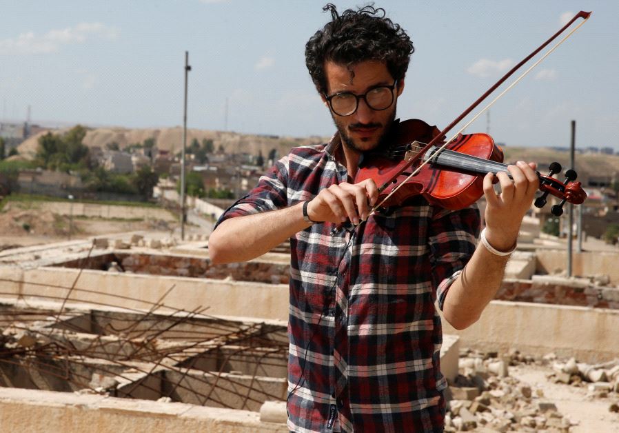 Ameen Mukdad, a violinist from Mosul who lived under ISIS's rule for two and a half years where they destroyed his musical instruments, performs at Nabi Yunus shrine in eastern Mosul, Iraq, April 19, 2017.