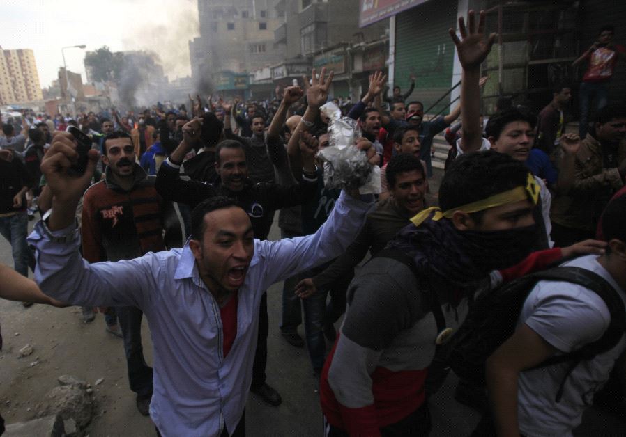 Supporters of the Muslim Brotherhood and ousted Egyptian President Mohamed Mursi shout slogans in front of riot police and army and their supporters, during clashes at El-Talbyia near Giza square, south of Cairo, November 29, 2013