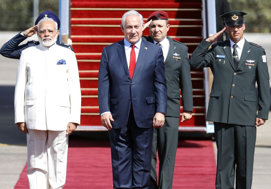 Prime Minister Benjamin Netanyahu (C) welcomes Indian Prime Minister Narendra Modi (L) during an official ceremoney at Ben-Gurion International airport near Tel Aviv on July 4, 2017